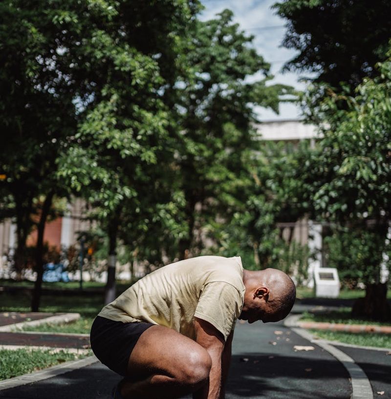 A man in athletic wear performing a dynamic bodyweight squat.